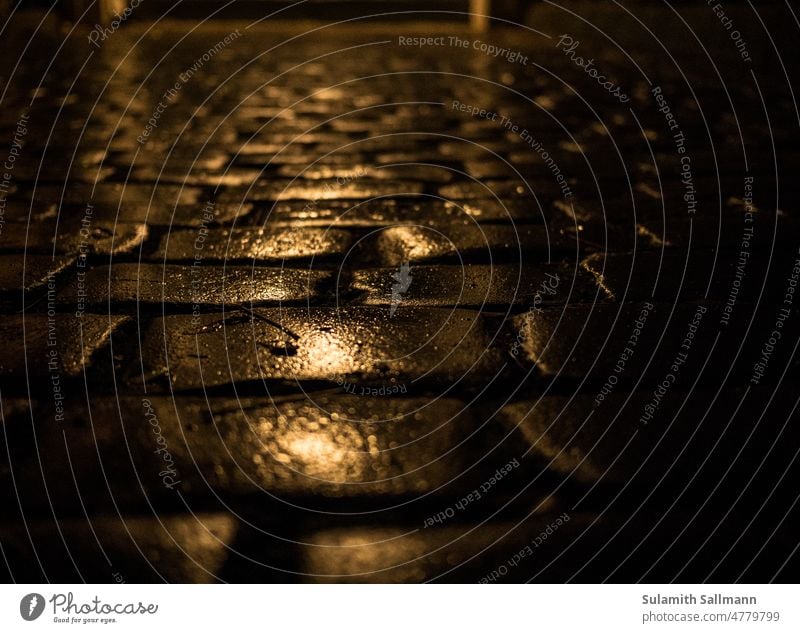 wet cobblestones at night off Evening background Dark Night shot Wet Surface cobblestone road paving texture slippery somber Eerie Ground Rainy weather rainy