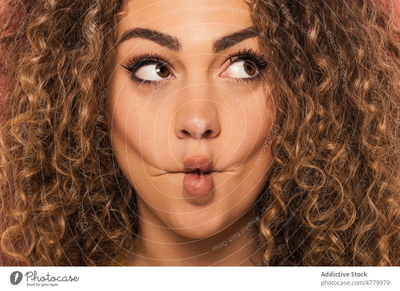 Young woman with bright makeup looking away with funny expression curly hair appearance lips expressive portrait ginger positive young style happy smile