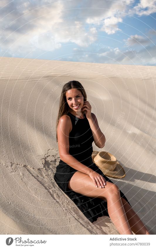 Traveler sitting in desert at sunset tourist stroll hill sky explore wanderlust nature woman landscape traveler cloudy vacation trip island spain corralejo dune