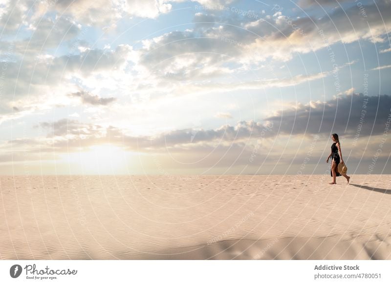 Traveler walking in desert at sunset tourist stroll hill sky explore wanderlust nature woman landscape traveler cloudy vacation trip island spain corralejo dune