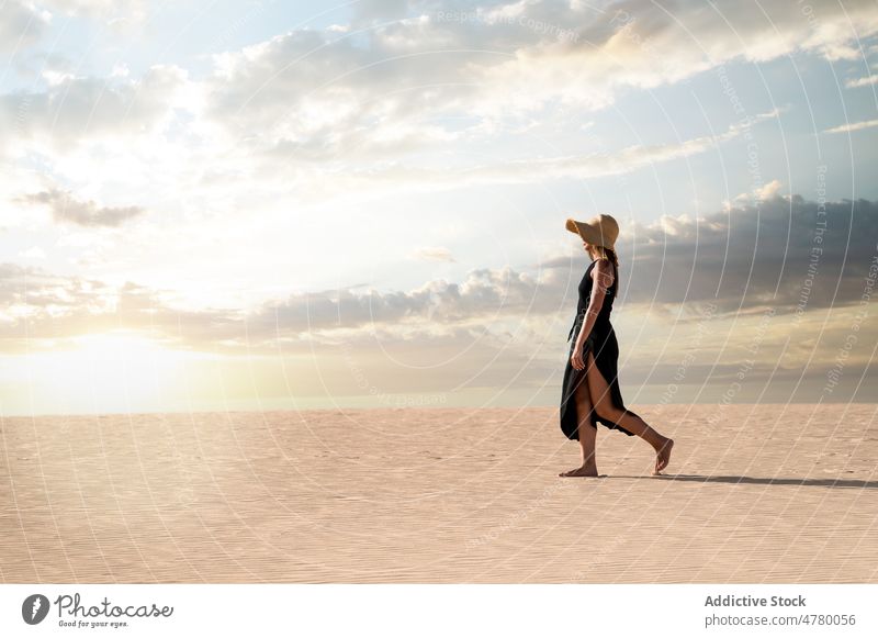 Traveler walking in desert at sunset tourist stroll hill sky explore wanderlust nature woman landscape traveler cloudy vacation trip island spain corralejo dune