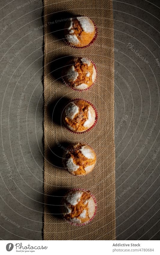 Row of delicious baked muffins sweet dessert pastry homemade row confection culinary treat neat arrange tasty still life yummy food palatable textile kitchen