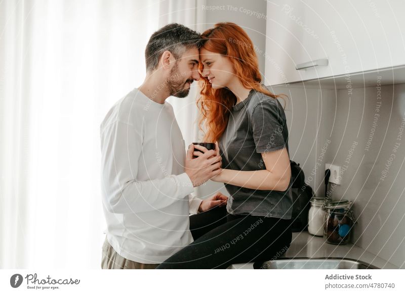 Couple caressing on kitchen counter couple relationship love bonding cuddle romantic affection redhead fondness coffee ginger together red hair home spend time