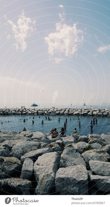 Calm blue Tyrrhenian Sea. View from the embankment of Naples to Mount Vesuvius volcano. Stone breakwater curves along the sea coastline background ocean