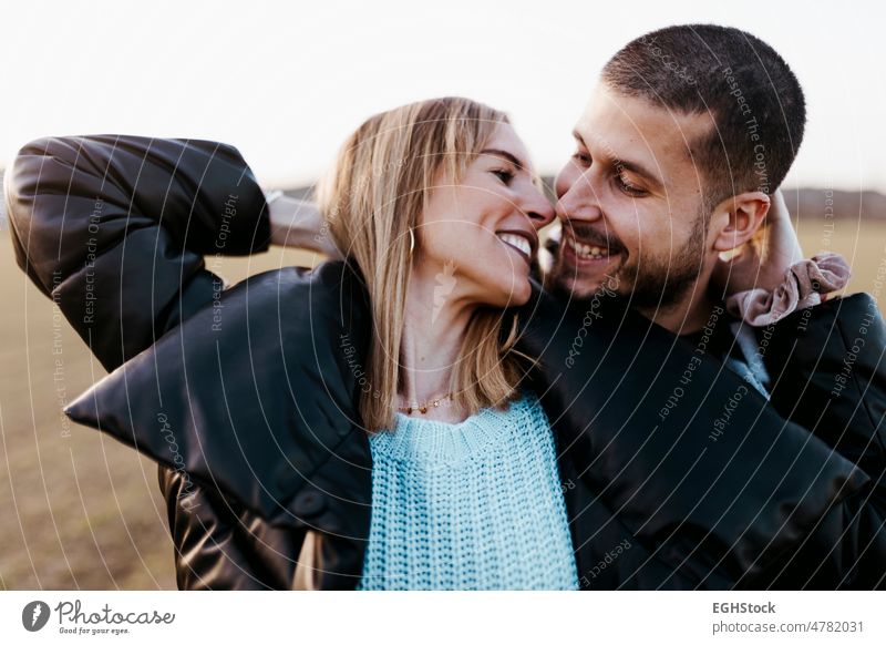 Female looking her boyfriend. Close up couple nose kissing in the countryside embraced. Boyfriend and girlfriend in love fall close up hugging two people