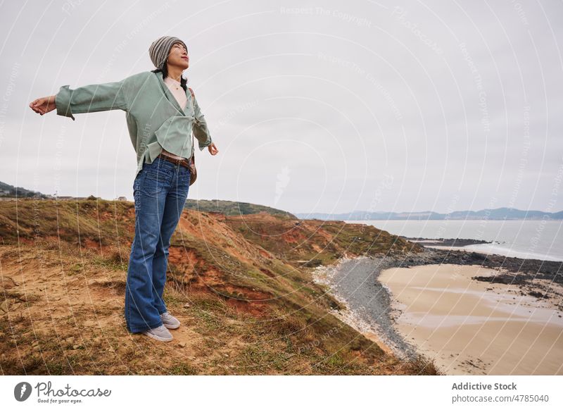 Asian girl feeling freedom in the seaside in Autumn time. Chinese girl woman one person people portrait winter autum Chinese people China tradition travel trip