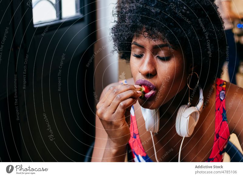 African American woman eating strawberry women bite enjoy breakfast healthy cafe young modern happy pleasure female black african american food yummy tasty