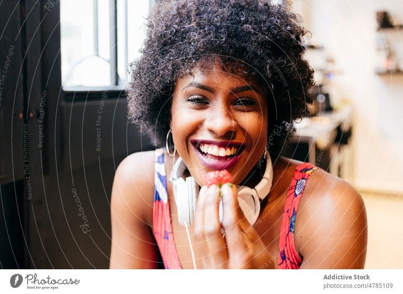 African American woman eating strawberry women bite enjoy smile breakfast cheerful delight healthy glad cafe young modern happy pleasure female black