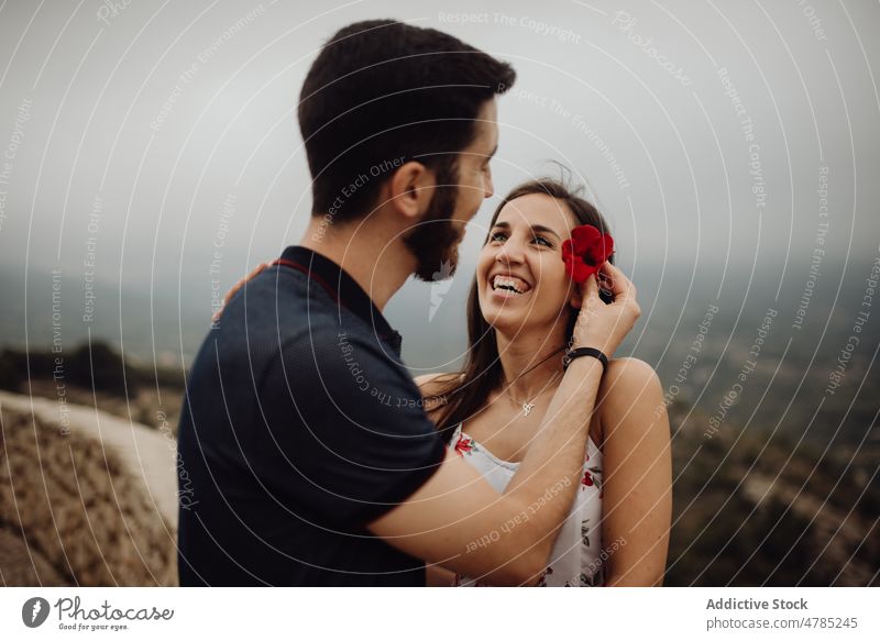 Sensual couple with red flower while resting on rural observation desk observation deck countryside landscape tender sensual passionate travel parapet hazy