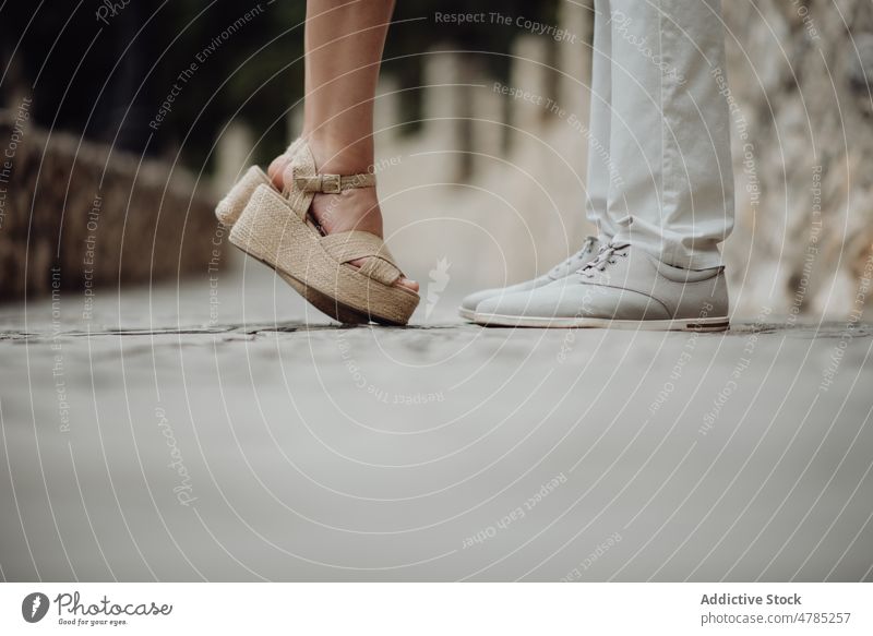 Romantic couple standing facing each other at summer street romantic kiss pebbled valentine pavement tiptoe sandals together relationship casual happy love city