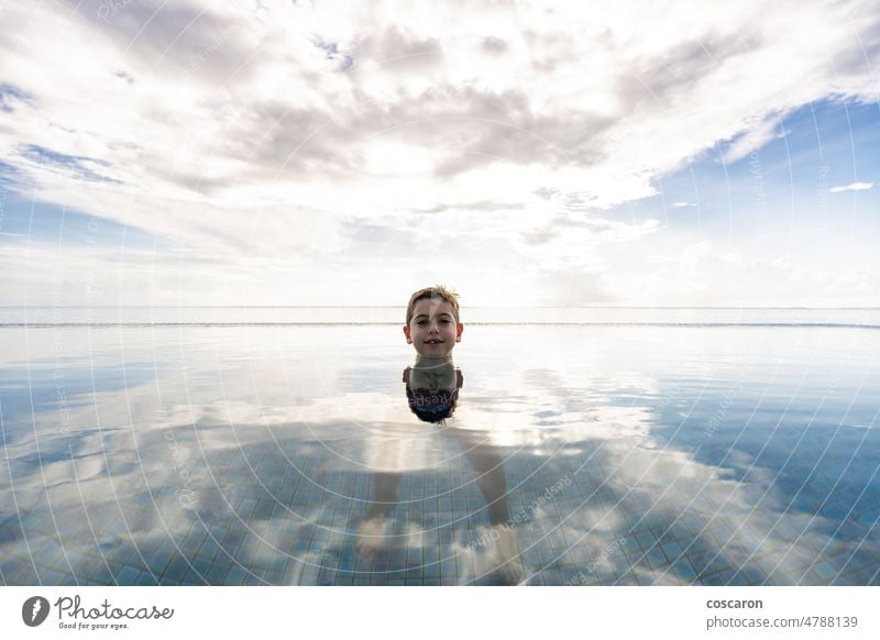 Little kid swimming on a pool of a hotel resort active people alone beach blue boy caucasian cheerful child childhood cute fun happiness happy have fun infinity