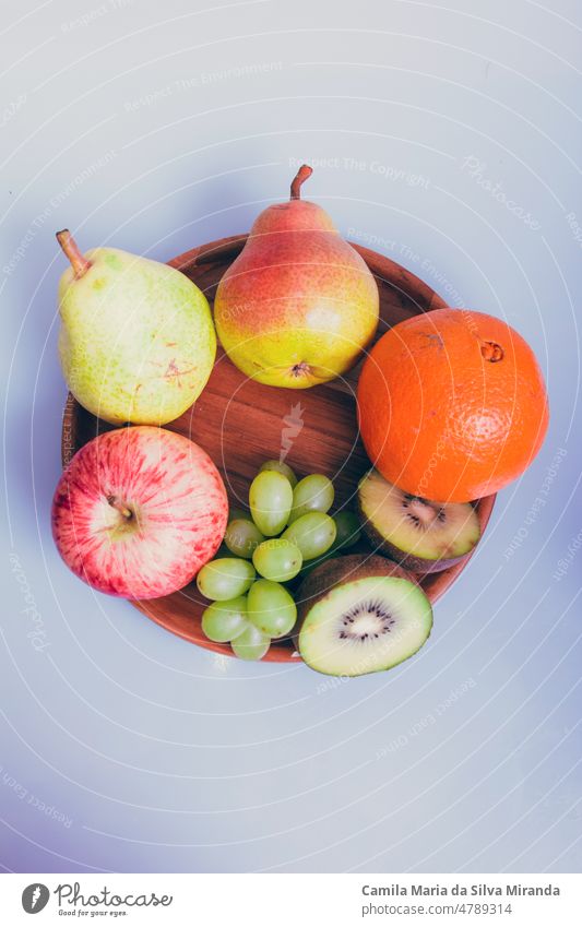 Assortment of fruits on a wooden plate and white background. agriculture appetizer apple assorted assortment citrus delicious dessert diet different eat food