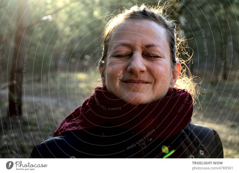 Forest bathing Trend Forest bathing shows effect, is a benefit and healthy for body, mind and soul as the face of the beautiful, smiling woman with closed eyes and the hair shining in the backlight proves