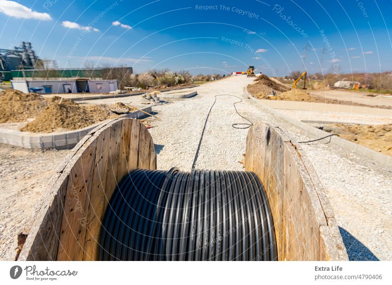 Unwinding cable of spool, coil at construction site Axle Big Black Bobbin Building Site Cable Cabling Carrier Civil Engineering Close-up Coil Connect Connection