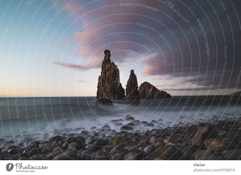 Magical place of Ilheu da Ribeira da Janela near the famous town of Porto Moniz in the northwest of the island of Madeira, Portugal. Long exposure at sunset on a rock washed by the ocean