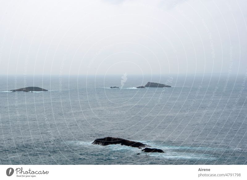 Island remnants - Remnant islands Ocean Horizon Dark Elements somber Loneliness Gray Bad weather Water Rock washed round Waves bleak Deserted Lonely Uninhabited