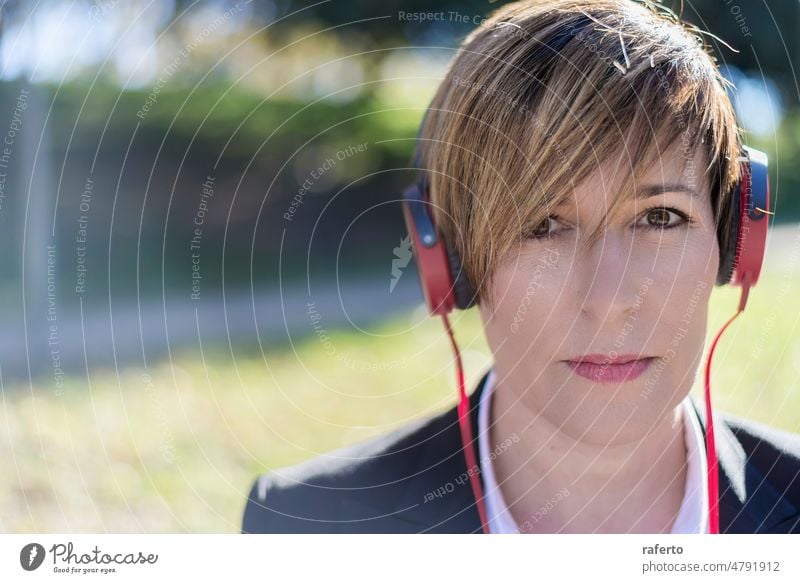 Relaxed woman listening to music and meditating outdoors in the nature bench earphones lifestyle outside female park relax young adult headset peace tranquility