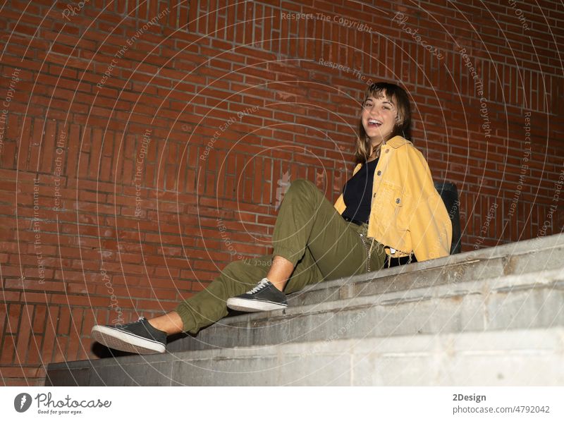 Young blond woman sitting on staircase outdoors in the city at night young female 1 beautiful attractive pretty happy girl person lifestyle portrait happiness