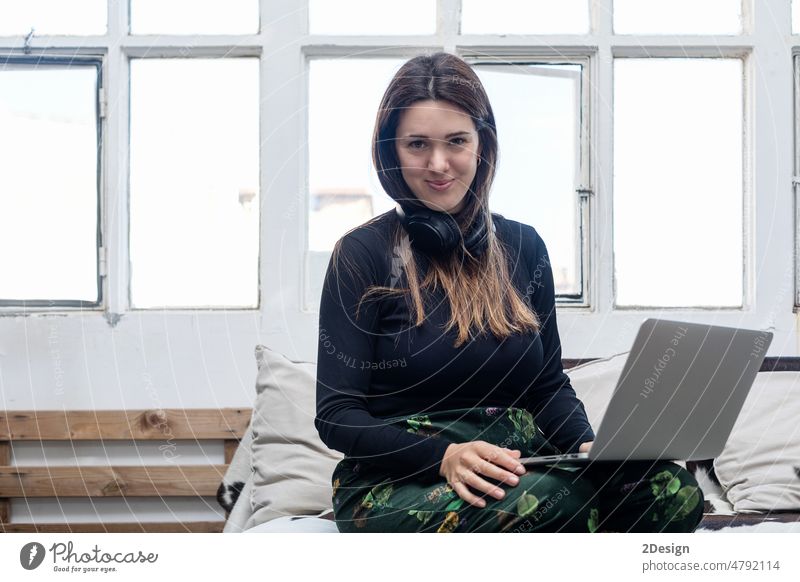 Beautiful Woman sitting on sofa and using laptop. caucasian woman 1 adult female couch computer person young technology room beautiful living room smile girl