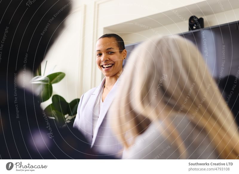 Portrait of multiracial LGBTQ mid adult businesswoman listening to female colleagues and smiling in meeting portrait lgbtq smile discuss leadership boardroom