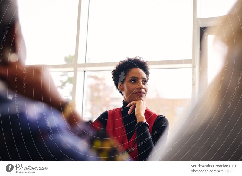 Portrait of pensive mature black businesswoman listening with hand on chin in meeting room portrait contemplation boardroom colleague teamwork three adult