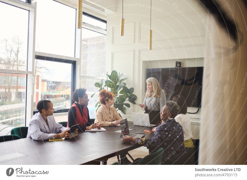 Portrait of senior white businesswoman discussing with multiethnic female colleagues in boardroom meeting portrait senor teamwork laptop talk listen leadership