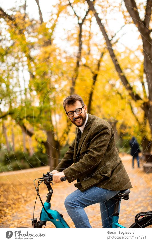 Young man with electric bicycle in the autumn park young nature lifestyle outdoor activity color ride summer bike day leisure people ebike travel sport city