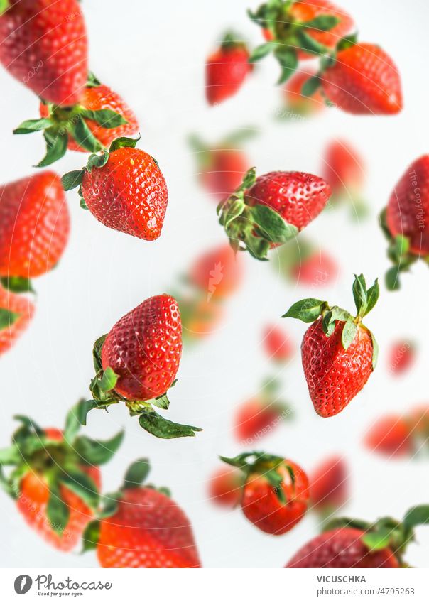 Flying strawberries at white background. flying delicious healthy summer food levitation falling fruits front view berry blurred effects fresh freshness heathy