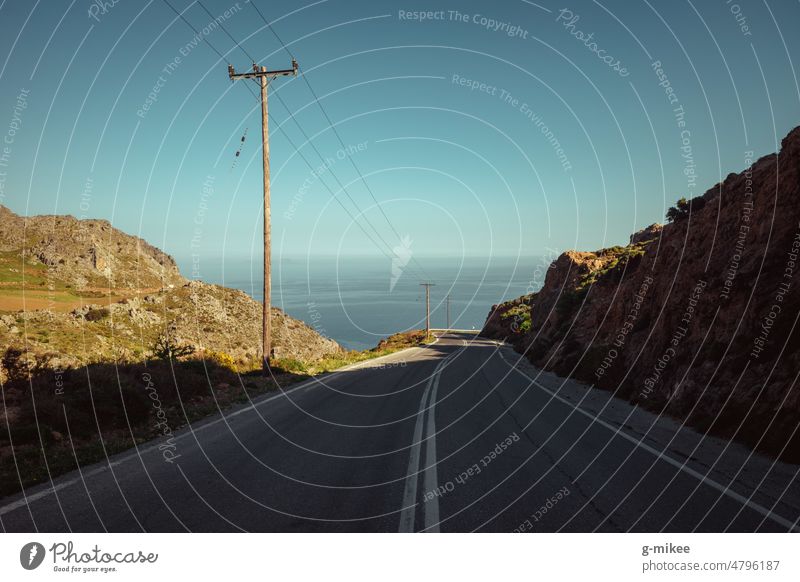 Empty road in the mountains by the sea Road in nature off void Mountains in the background Island vacation Loneliness Nature travel Street Summer Adventure Trip