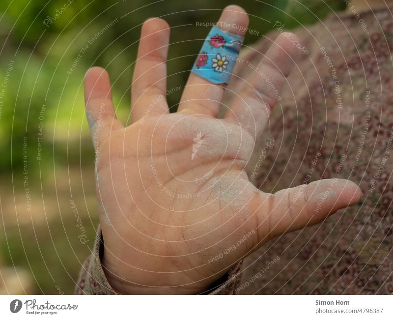 Child hand with plaster Children`s hand pavement Chalk violation Children's game Hand Infancy Healthy Creativity Joy Symbols and metaphors heal Street painting