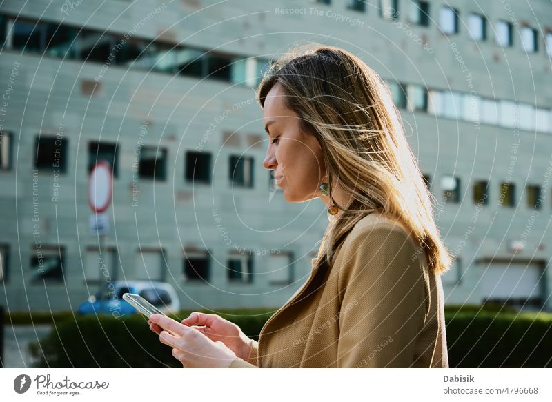 Caucasian woman using smartphine at city street smartphone portrait lifestyle walk businesswoman outdoor message tourist travel device communication