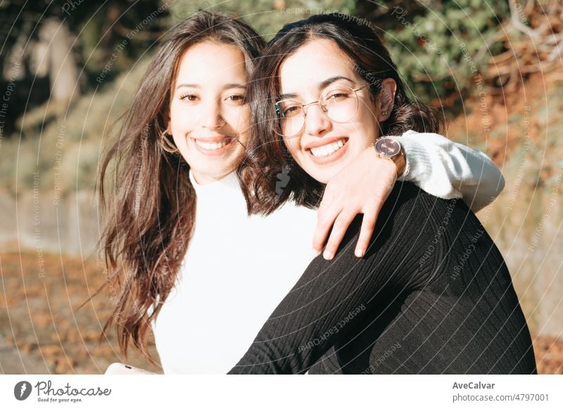 Two young sister embracing each other outdoors the university happy to start a new way on the life, studying together. Muslim Moroccan girls on europe. Happy integration concept.