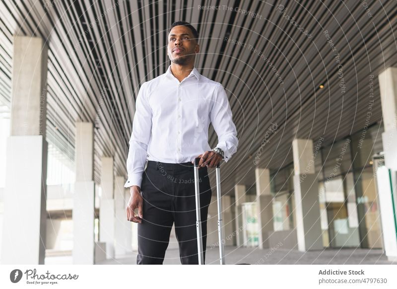 Black businessman with suitcase near building entrepreneur urban city luggage trip street formal style modern well dressed african american black respectable