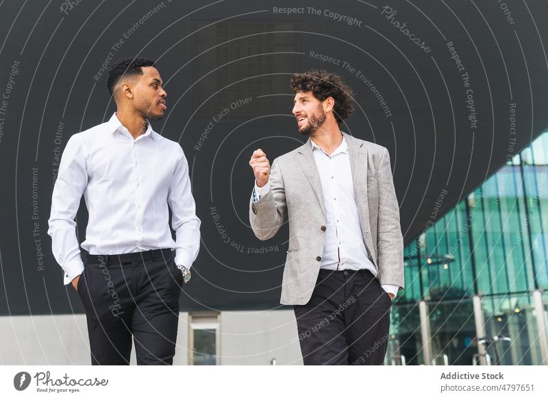 Positive multiethnic businessmen standing near office building colleague entrepreneur urban street formal modern optimist coworker multiracial diverse