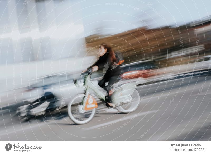 cyclist on the street mode of transportation in the city biker bicycle cycling biking exercise activity lifestyle ride speed fast blur blurred motion movement