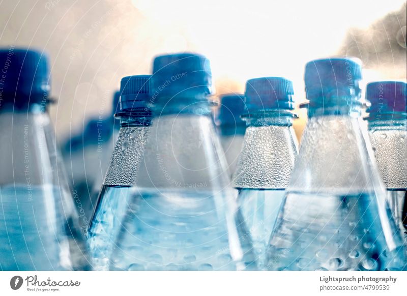 Closeup on plastic water bottles in raw and lines. environmental pollution thirsty ecosystem group of objects drink recycling liquid isolated blue mineral white