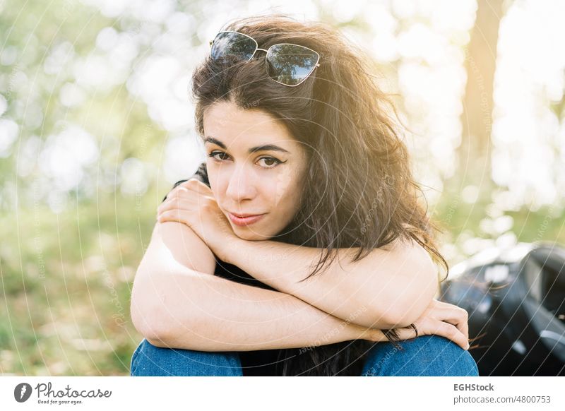 Young woman in nature sitting resting on her motorcycle route with her helmet behind young female sunglasses person biker rider lifestyle drive motorbike