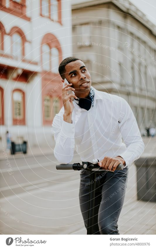 Young African American using mobile phone while standing with electric scooter on a street active activity african american attractive beautiful black casual