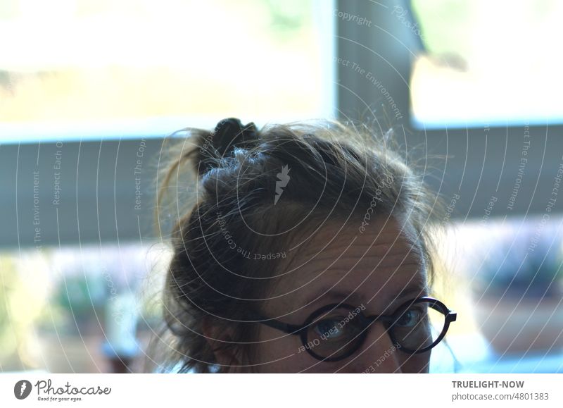 Skepticism, doubt, pain, guilt, face of a woman at the window, looking into the camera with big eyes, dark glasses, forehead in wrinkles, powerful hair tied up, cropped portrait