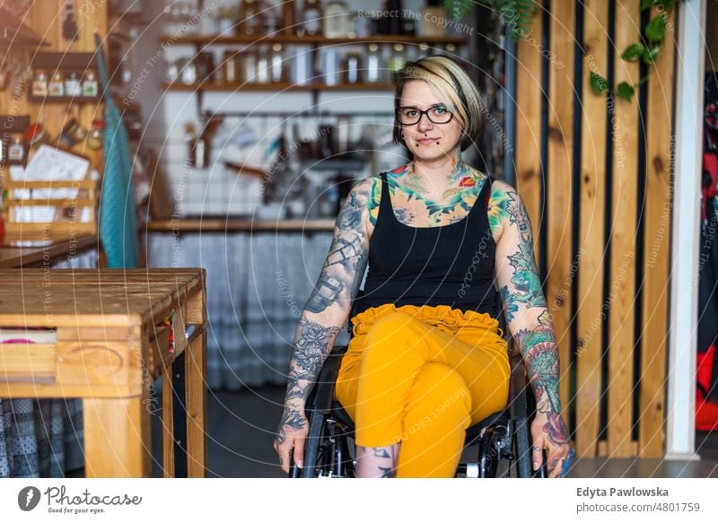 Portrait of an young tattooed woman in a wheelchair at home domestic life confidence indoors house people adult casual female Caucasian attractive beautiful