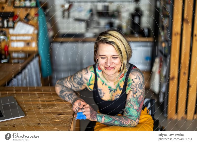 Portrait of an young tattooed woman in a wheelchair at home domestic life confidence indoors house people adult casual female Caucasian attractive beautiful