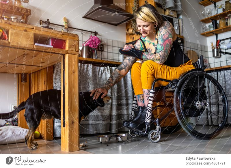 Young woman with disability with her dog at home wheelchair domestic life confidence indoors house people young adult casual female Caucasian attractive