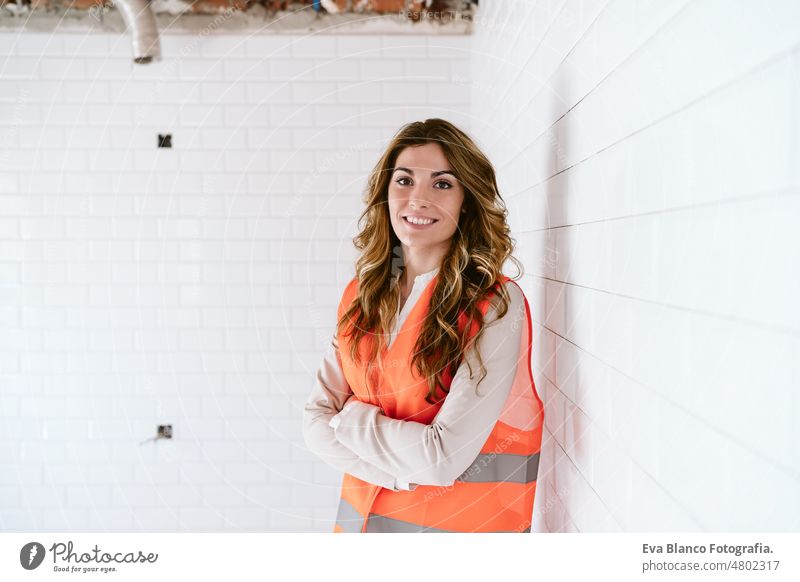 inspector or architect professional woman checking kitchen at construction site. Home improvement portrait blueprints workspace protective helmet