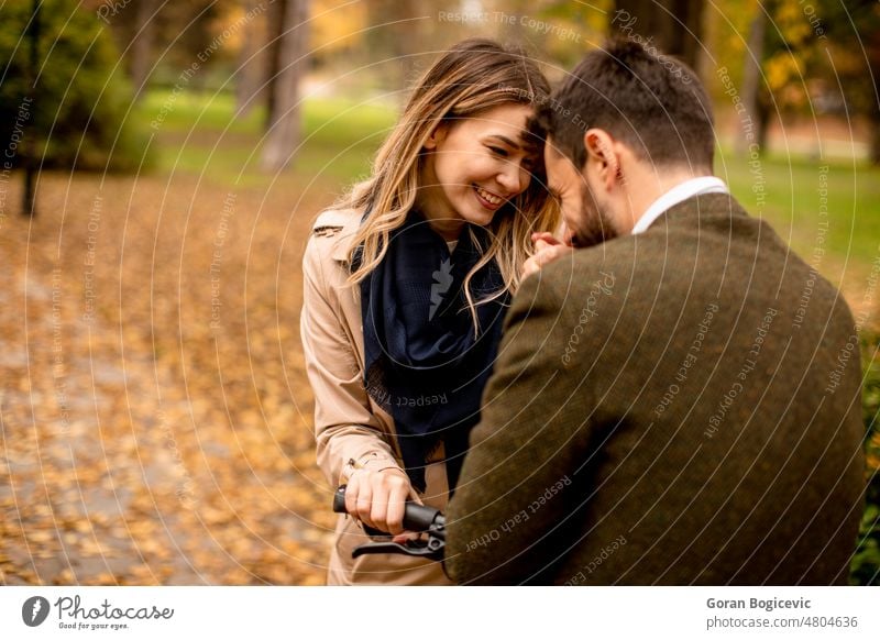 Young couple in the autumn park with electrical bicycle attractive autumnal beautiful boyfriend casual color date dating day ebike enjoy fall female foliage