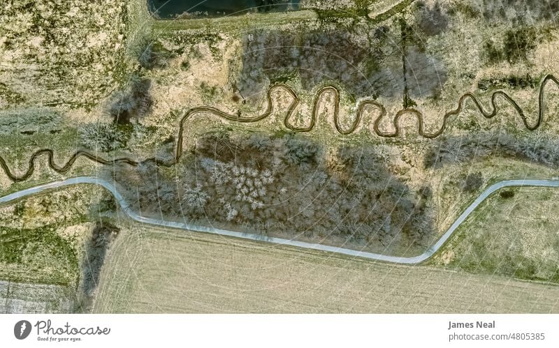 A trail follows a stream in springtime grass natural foliage peaceful nature water day beauty background trees creek wild united states curve wisconsin spiral