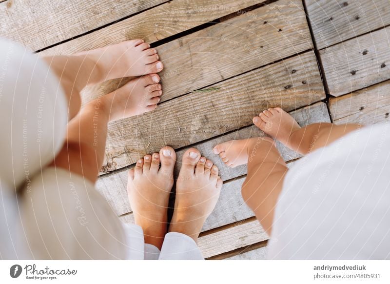 Family of three. mother and two kids playing outside. Legs of unrecognizable people. Happy family standing outdoors in warm summer day. Family concept. People on vacation enjoying nature