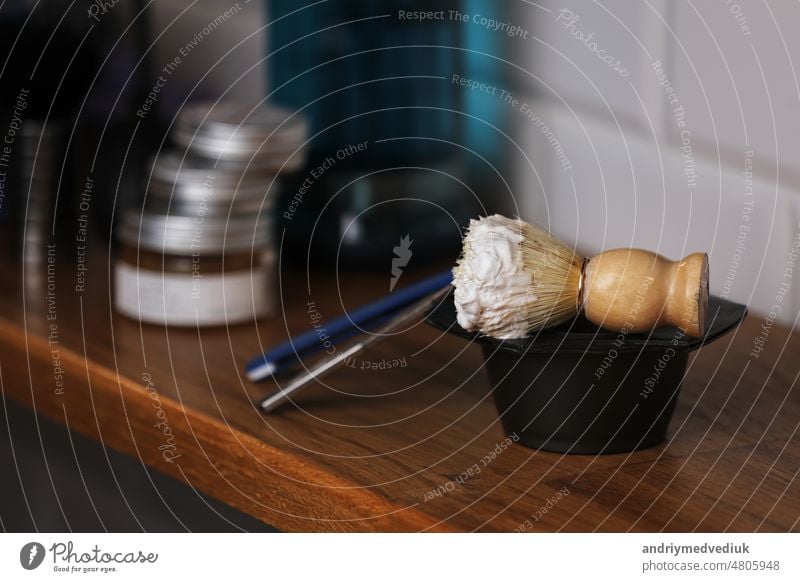 Set of shaving equipment and men's cosmetic products on wooden table, barbershop. shave concept with a straight razor, shaving brush and foam. beard care products for men on background.