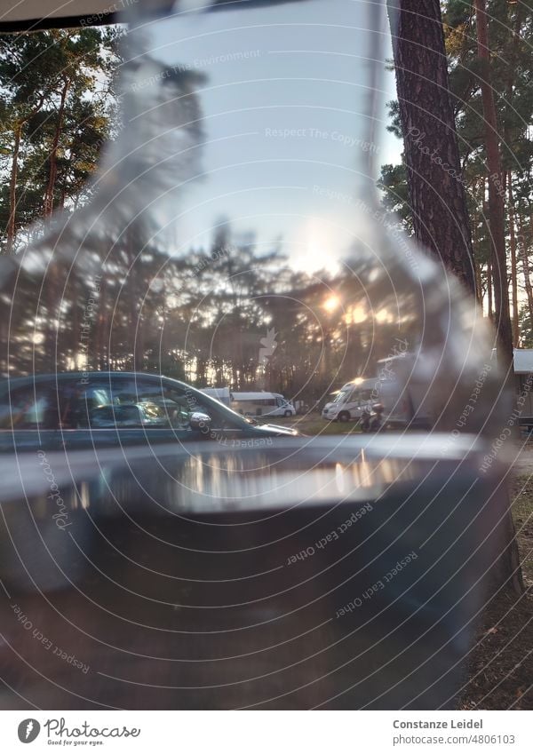 View through a water bottle to the sunset through trees. outlook Deserted Day Mobile home romantic Wanderlust voyage Retro Window Mobility Caravan Meadow