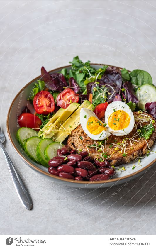 Medium boiled eggs with sasld, healthy breakfast soft-boiled diet bread yolk yellow medium boiled egg toast green salad leaves avocado cherry tomatoes cucumber