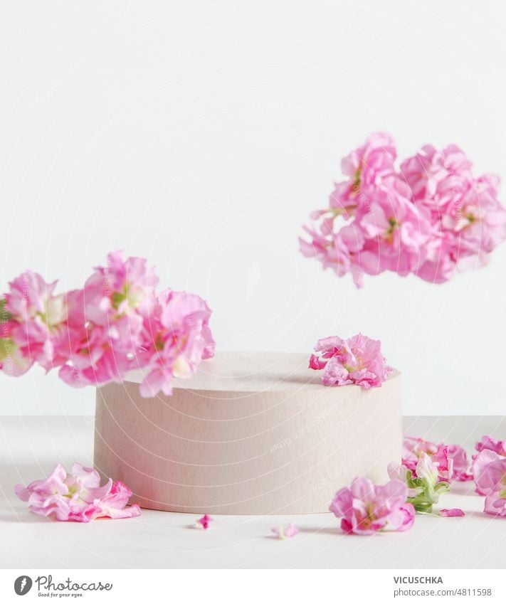 Modern floral product display with podium, flying pink flowers at white background. modern scene stage showcase front view copy space blossom concept design